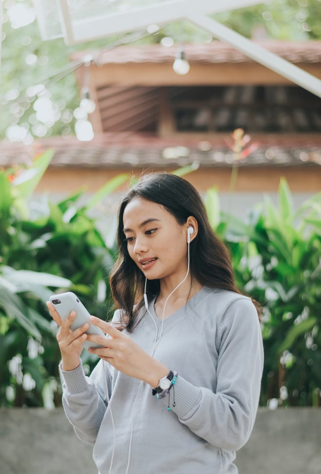 Woman Using Phone with Earphones